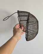 Side profile of 19th-century fencing mask with sculptural wire mesh construction