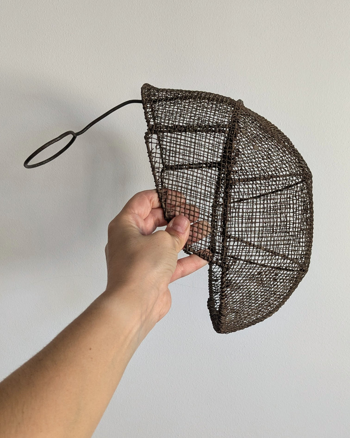 Side profile of 19th-century fencing mask with sculptural wire mesh construction