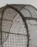 Close-up of aged iron patina and woven mesh on antique fencing mask