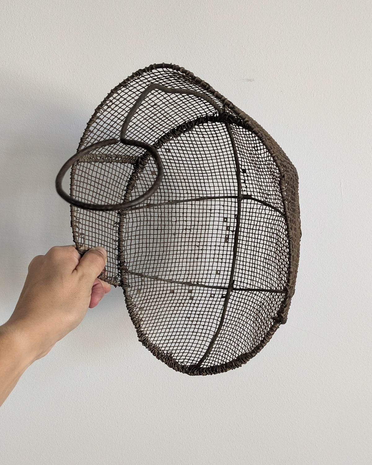 Rear view of antique French fencing mask showing metal support and strap loop