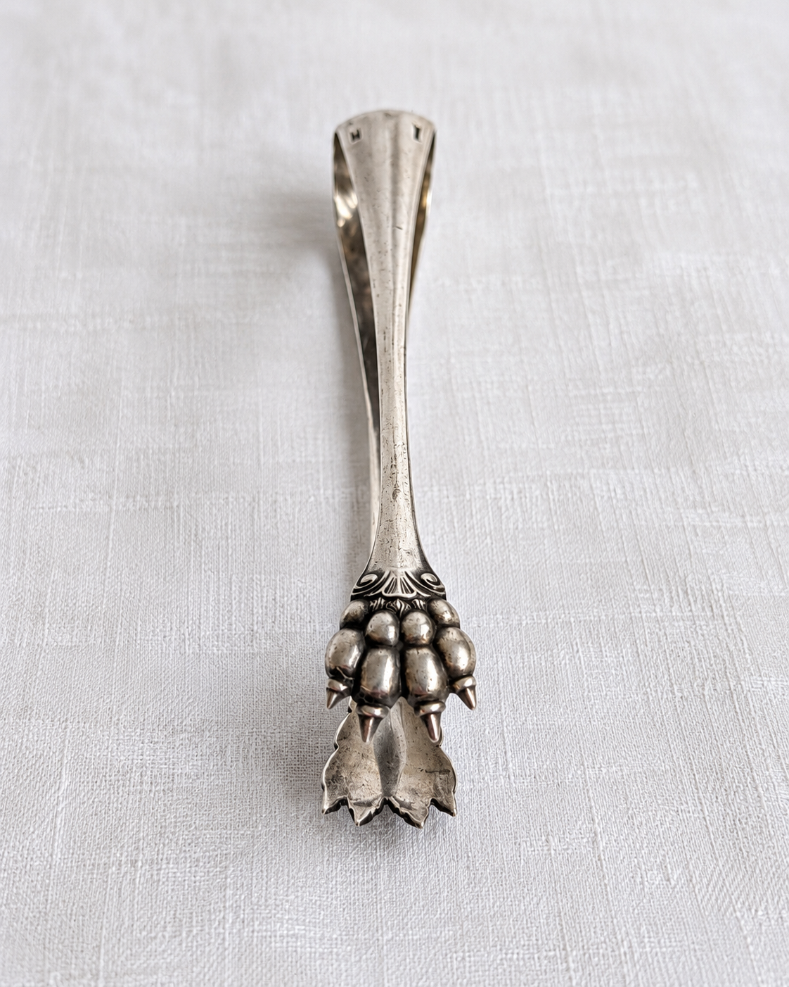 Detail of sculpted lion claw on Christofle silver-plated sugar tongs