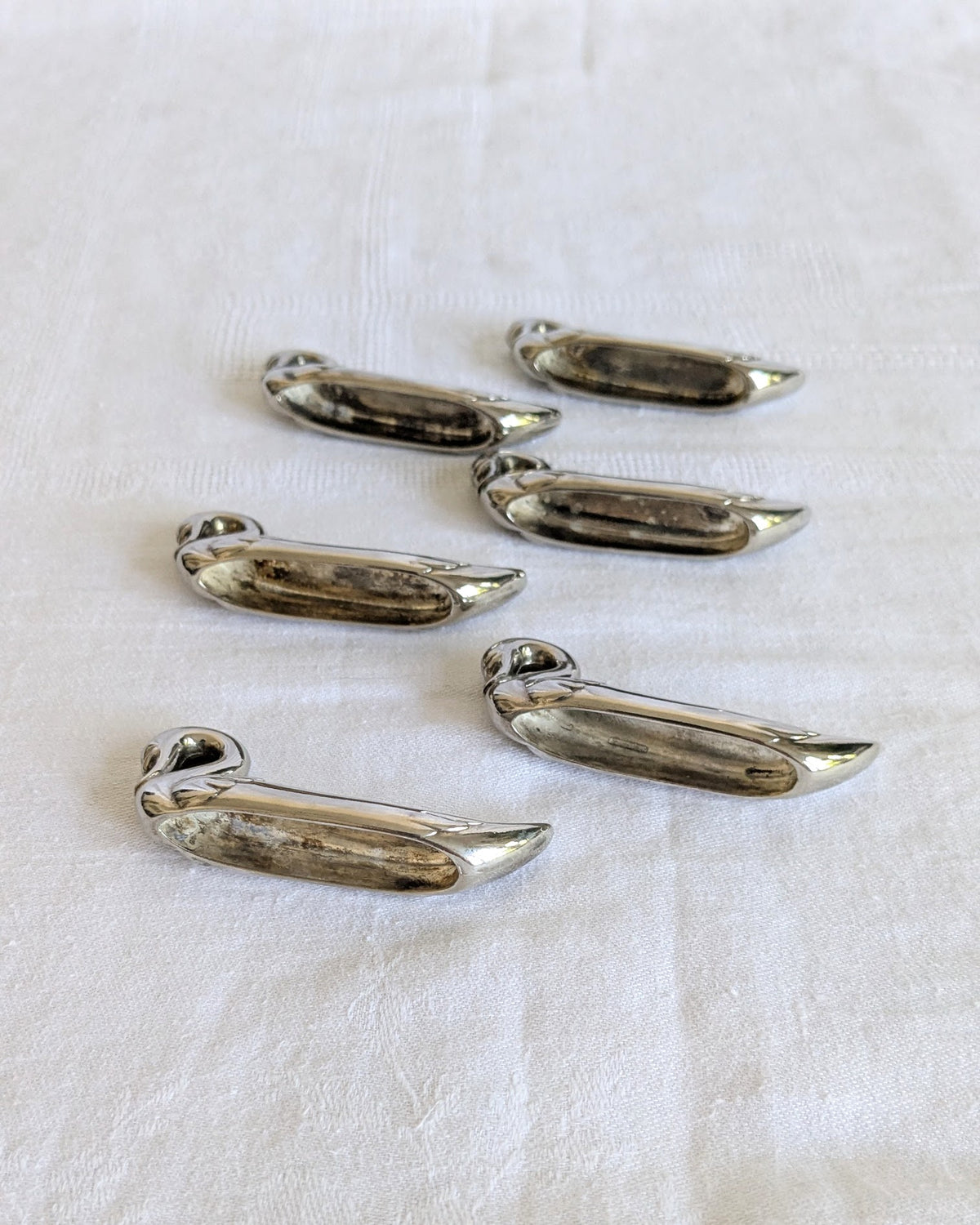 Side view of vintage stainless steel swan knife rests